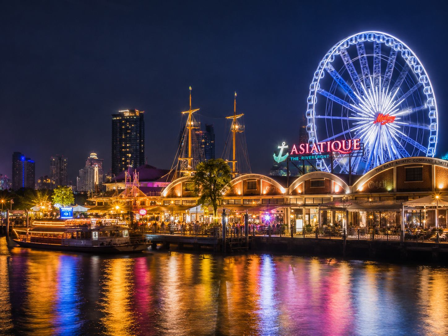 Asiatique The Riverfront at night with illuminated 60-metre Ferris wheel reflecting on the Chao Phraya River, Bangkok