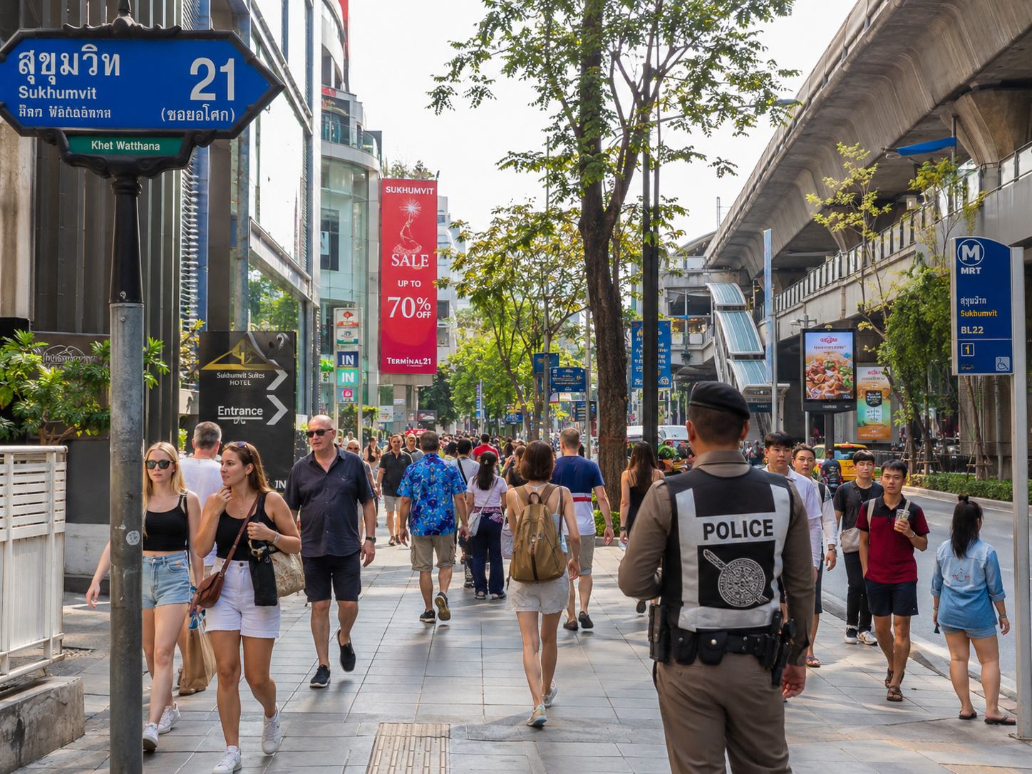 Busy Sukhumvit Road in Bangkok with BTS Skytrain overhead — a central, safe area for tourists near Nana BTS station